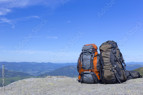 Camping with backpacks in the mountains against the blue sky.