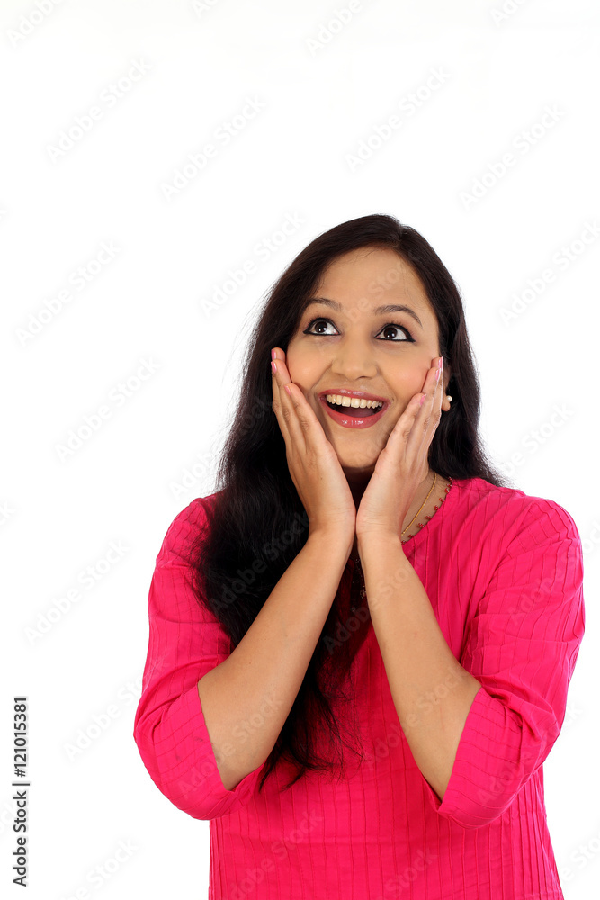 Surprised young woman looking up against white background Surprised young woman looking up against white background