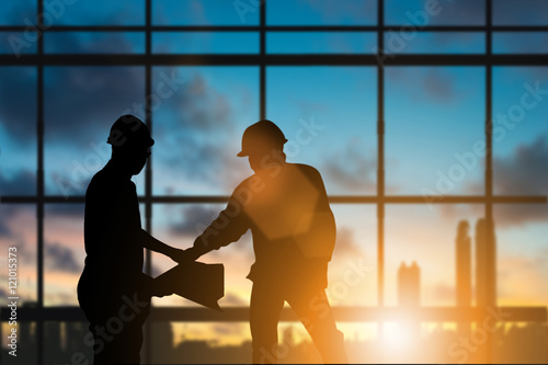 Silhouette engineer standing orders for construction crews to work safely on high ground over blurred natural background sunset pastel. heavy industry and safety at work concept. photo