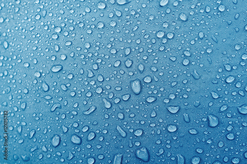 Water droplets on blue fiber waterproof fabric. photo