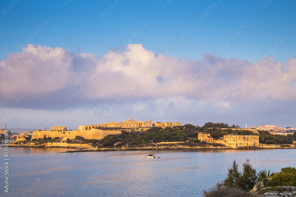 Manoel Island with Fort Manoel at sunrise with fishing boat and beautiful clouds