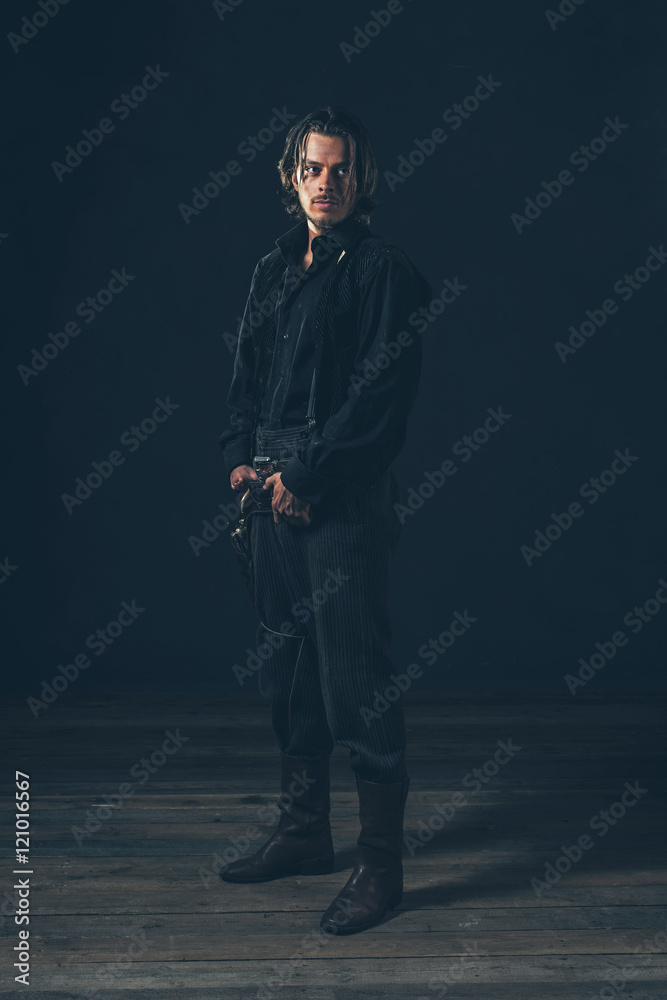 Retro 1900 western man. Young adult. Studio shot against dark ba Retro 1900 western man. Young adult. Studio shot against dark ba