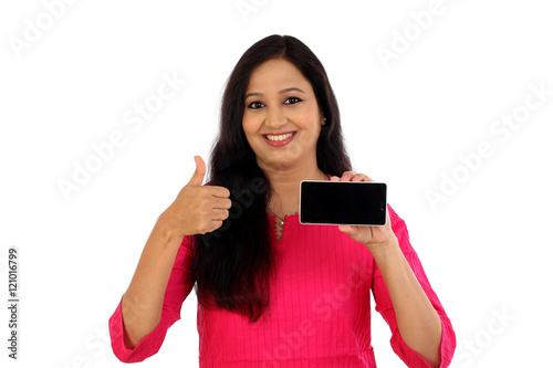 Happy young woman holding mobile photne against whtie background