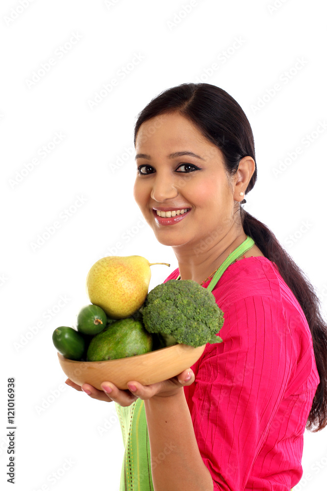 Smiling female chef holding bowl full of vegetables and fruits Smiling female chef holding bowl full of vegetables and fruits