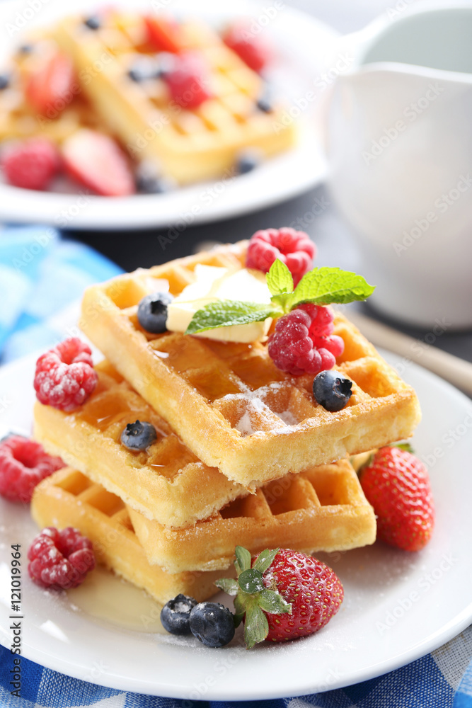 Homemade waffles with berries in plate on grey table Homemade waffles with berries in plate on grey table