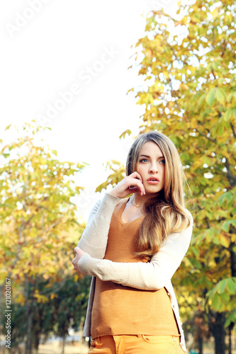 Beautiful young girl in autumn park, outdoors