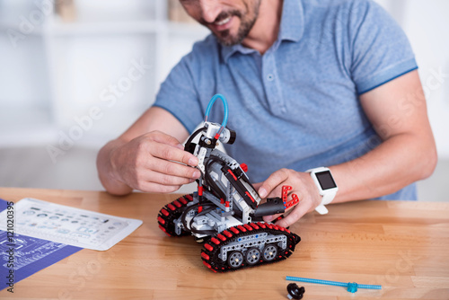 Male making cute small robot on the table