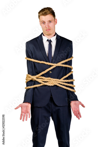 Young businessman in a suit tied up with rope photo