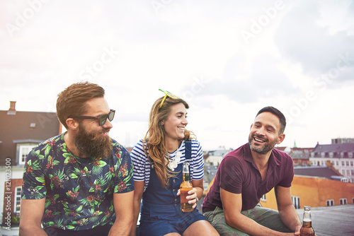 Cheerful group of adults drinking on roof