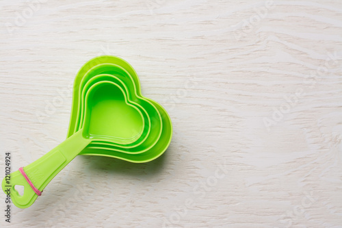 Green mold heart forms for muffins on the wooden background.Heart Cake Mold for making cake
