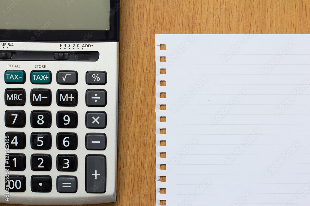 White paper and calculator on wood table White paper and calculator on wood table