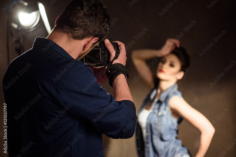 Man photographing woman in studio Man photographing woman in studio