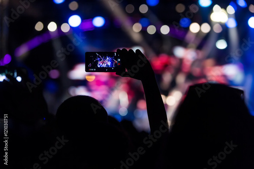 People taking photographs with touch smart phone during a music