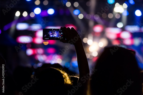 People taking photographs with touch smart phone during a music