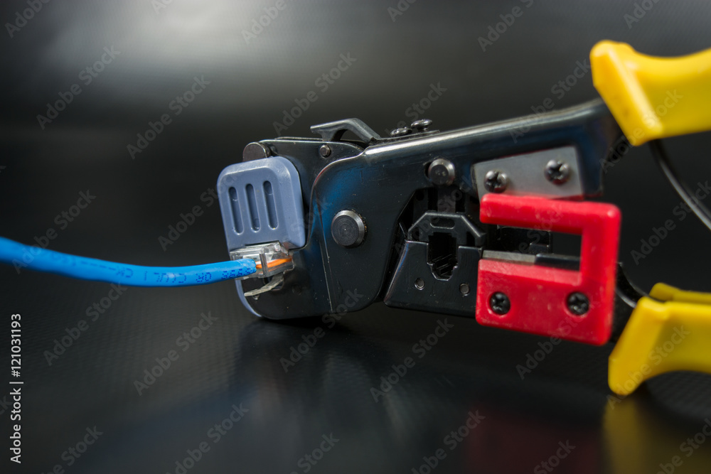 Crimping tool for twisted pair on black background.