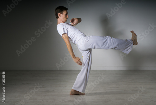 Man in sportswear performing a kick. © Vasily Merkushev