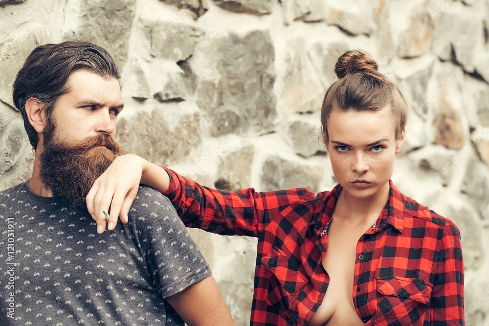 Couple smoking on stony wall background Couple smoking on stony wall background