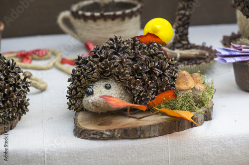 Foto Hedgehog from cones with an apple on his back