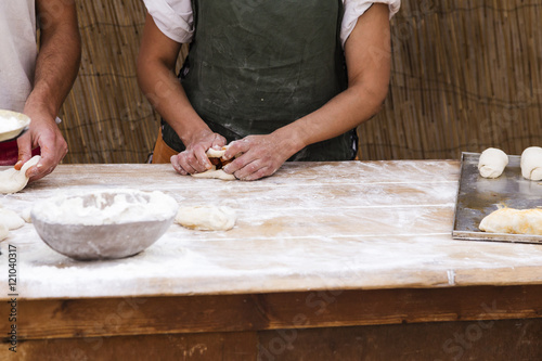 woman hands kneading bread on a wooden table 