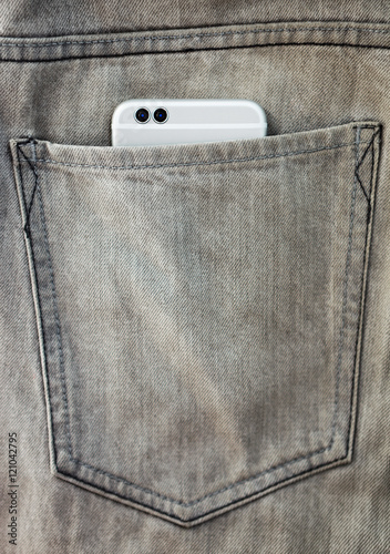 Modern dual camera smart phone in jeans pocket photo