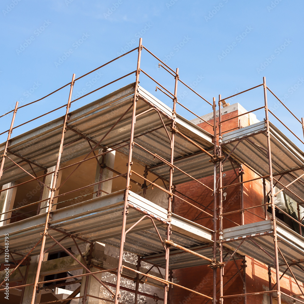House for renovation with the scaffolding for bricklayers House for renovation with the scaffolding for bricklayers
