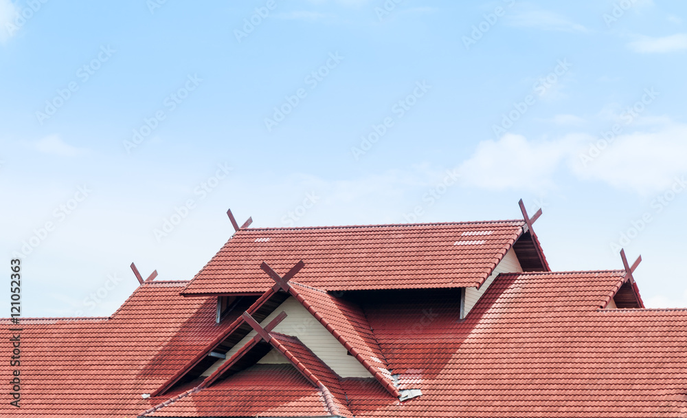 red Roof house with tiled roof on blue sky