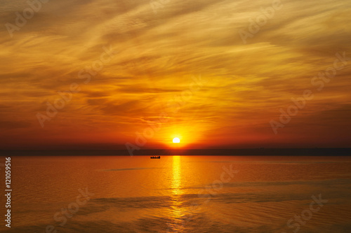 Bright sunset. Tranquil Sea. Fishing boat in the rays of the setting sun © marina_larina