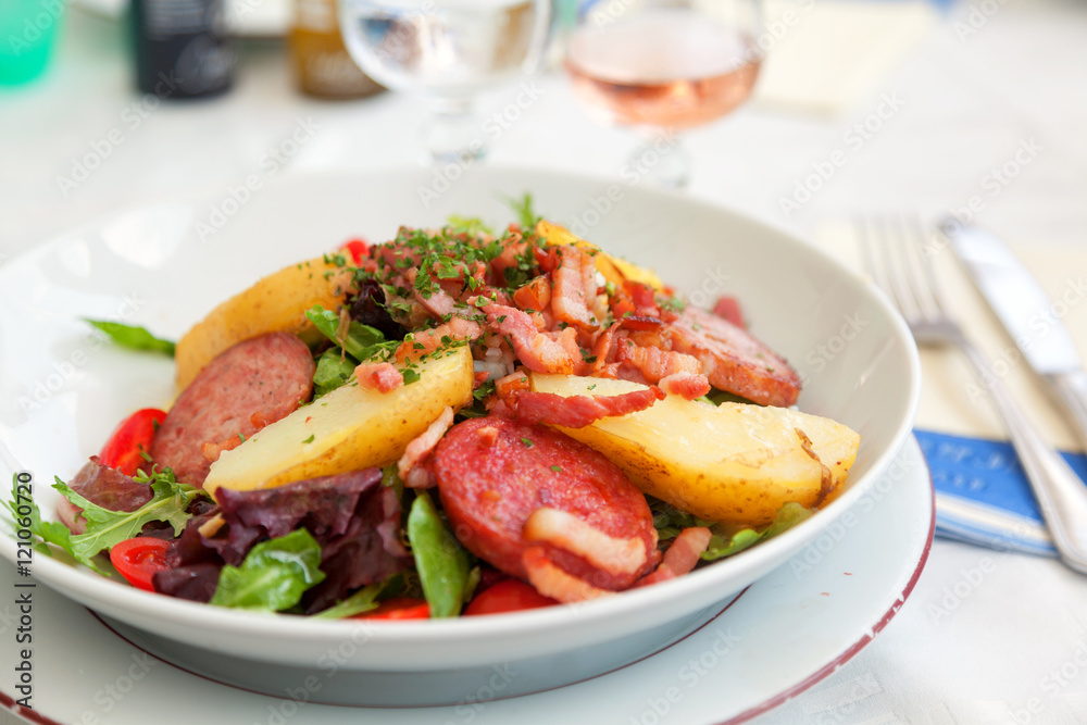 Gourmet salad with vegetables and fried ham served in a small be Gourmet salad with vegetables and fried ham served in a small be