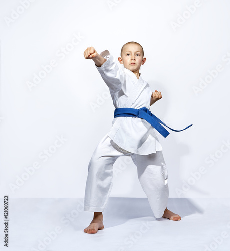 Straight punch arm karateka is beating with a blue belt