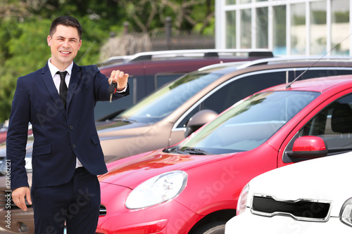 Man with car key outdoors