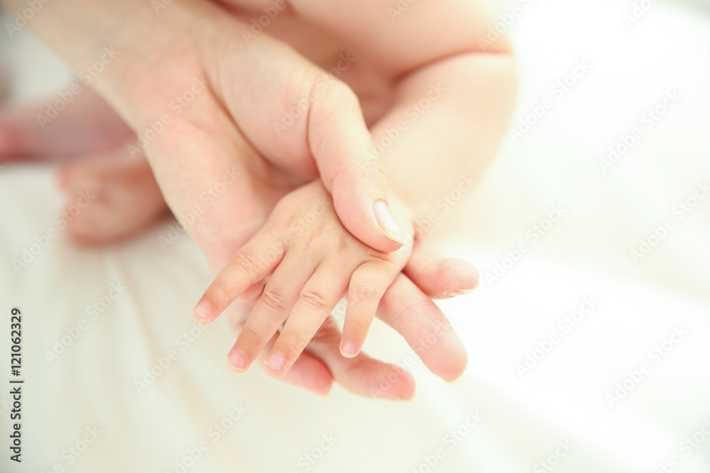 Mother holding baby hand, closeup