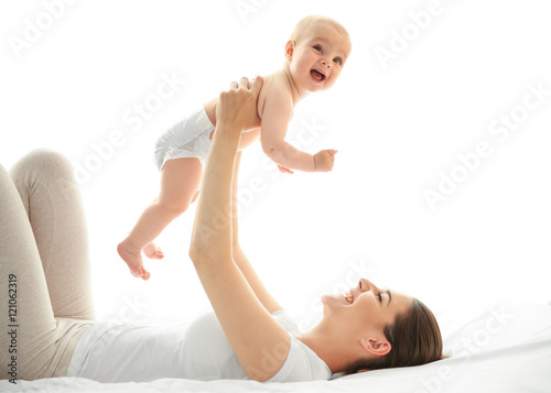 Mother and baby playing on bed
