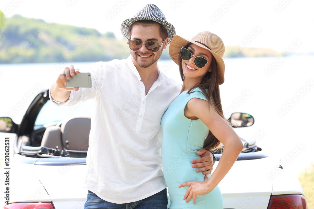 Couple taking selfie on river shore