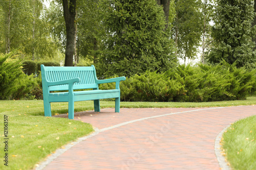 Blue wooden bench in beautiful park © Africa Studio