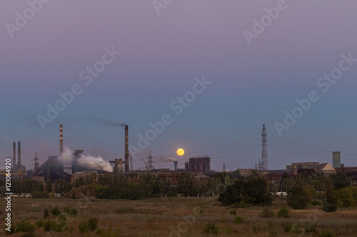 Picture of metallurgical plant and its Smoking chimneys in the background of clear sky