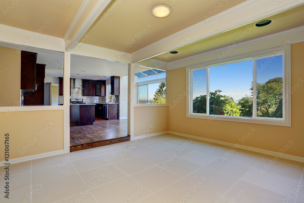 Fototapeta premium Open floor plan. Empty room with tile floor. View to kitchen room.