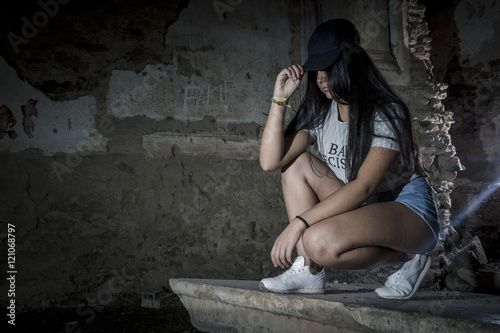Moda con estilo swag. Chica joven posando con visera. Sesión con modelo dentro de un castillo.
