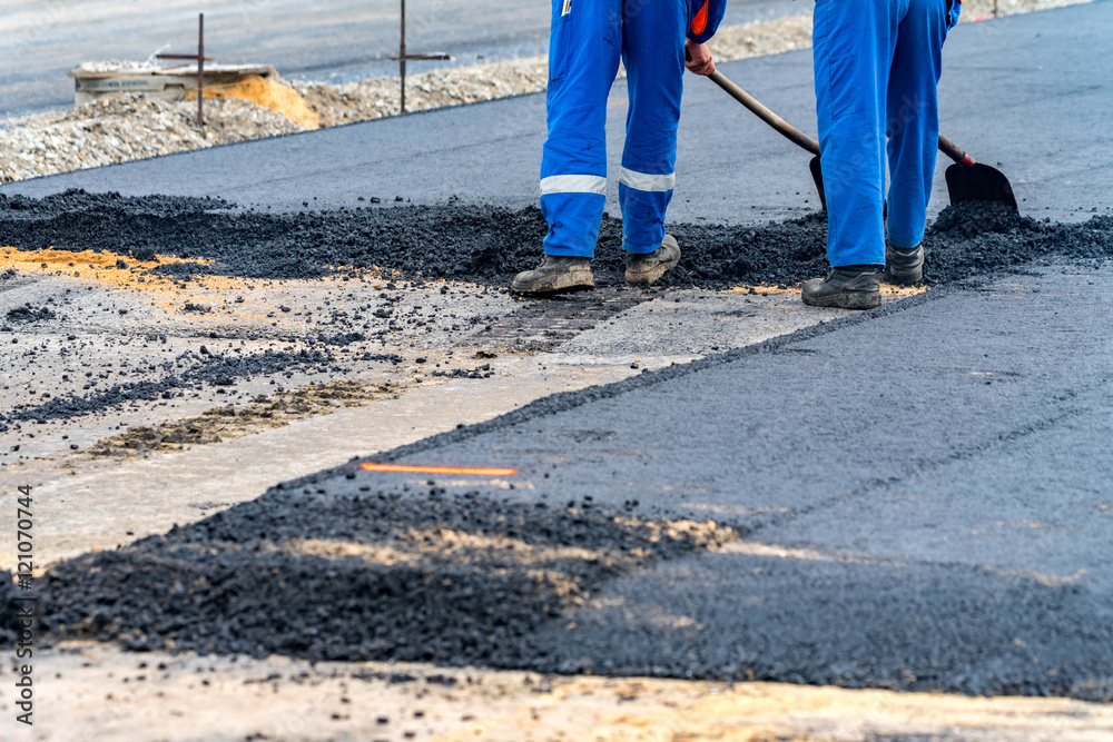 The workers and the asphalting machines