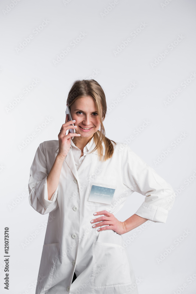 Female doctor talking on the cell phone isolated over white background Female doctor talking on the cell phone isolated over white background
