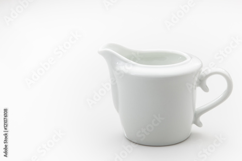 Φωτογραφία White ceramic creamer on a white background.