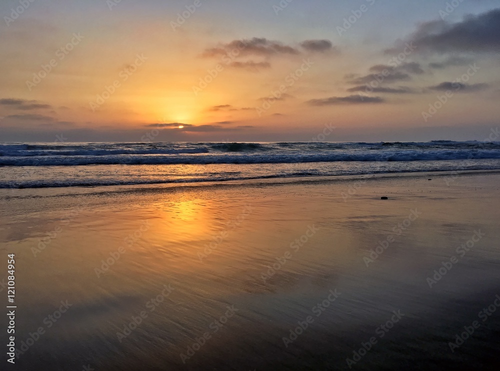 Beautiful sunset with reflections along empty beach