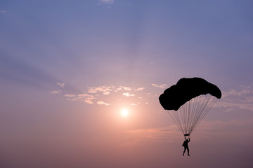 Fotobehang Luchtsport Parachutespringer silhouet bij zonsondergang  © yotrakbutda