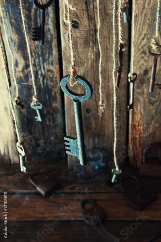 Many keys hanging on a string. Wooden background. Selective focus © inventart
