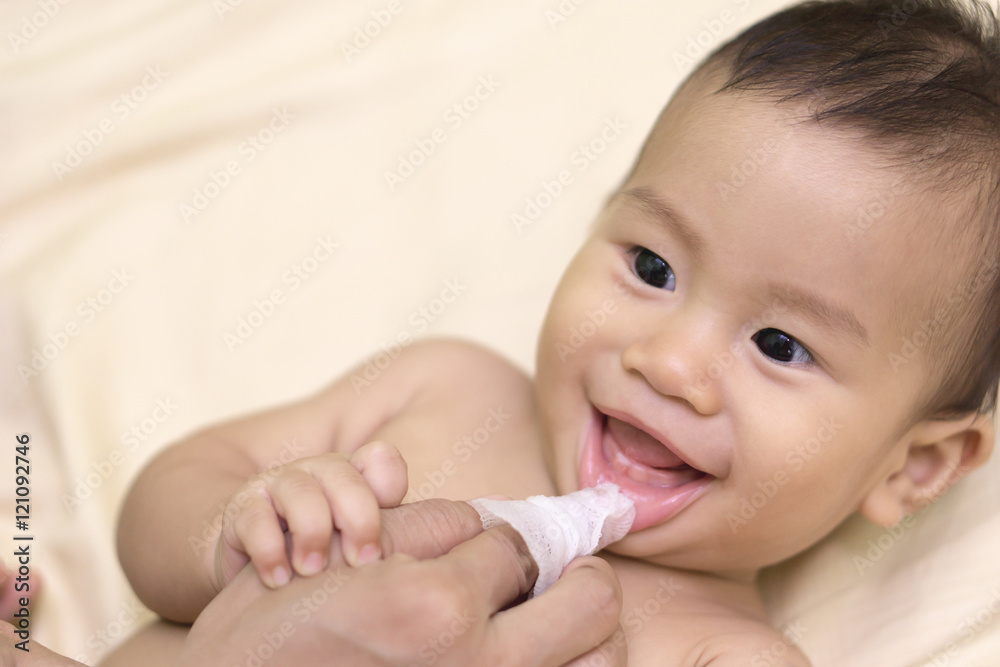 Mother cleans baby mouth
