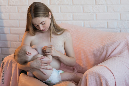 Young and beautiful mother breastfeeding baby hold in hand,motherhood,family