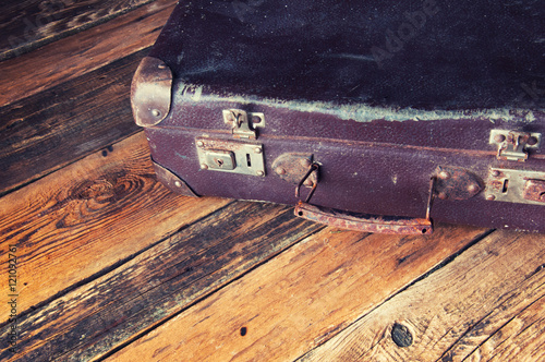 Vintage suitcase on wooden floor. Copyspace. Top view.