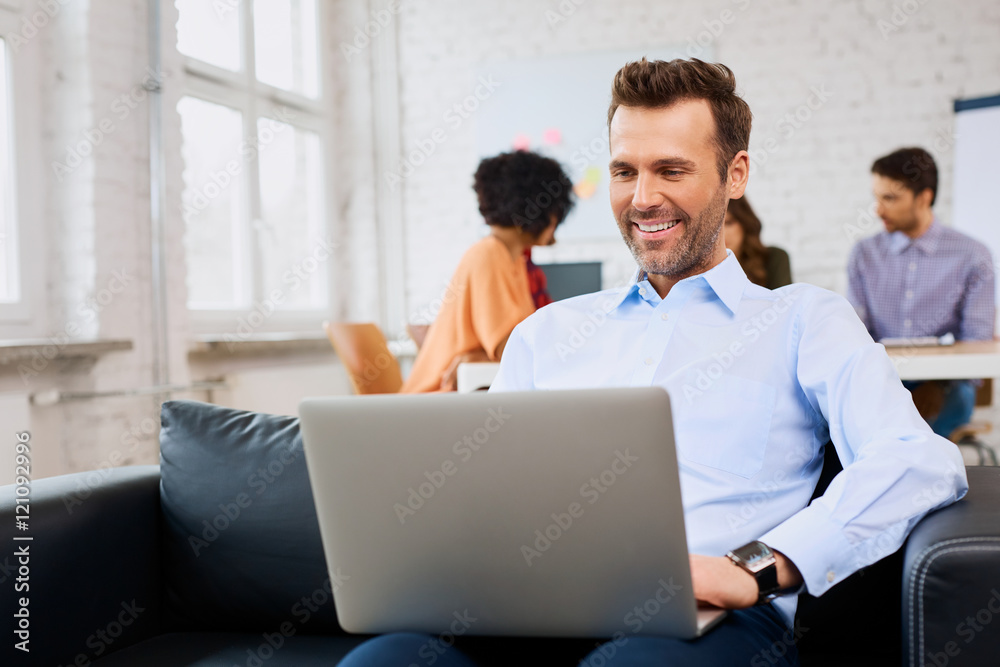 Businessman sitting on couch at office
