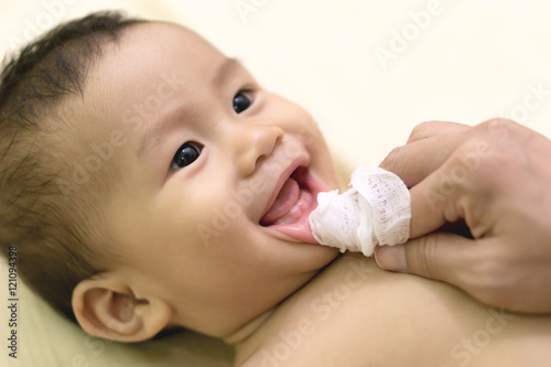 Mother cleans baby mouth