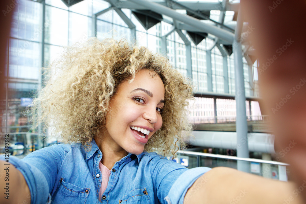 Smiling young african american woman taking selfie