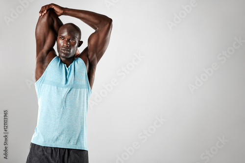 Strong young muscular man stretching his arms